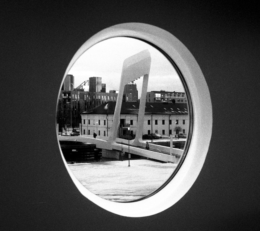 a black and white photo of a bridge over a river with buildings