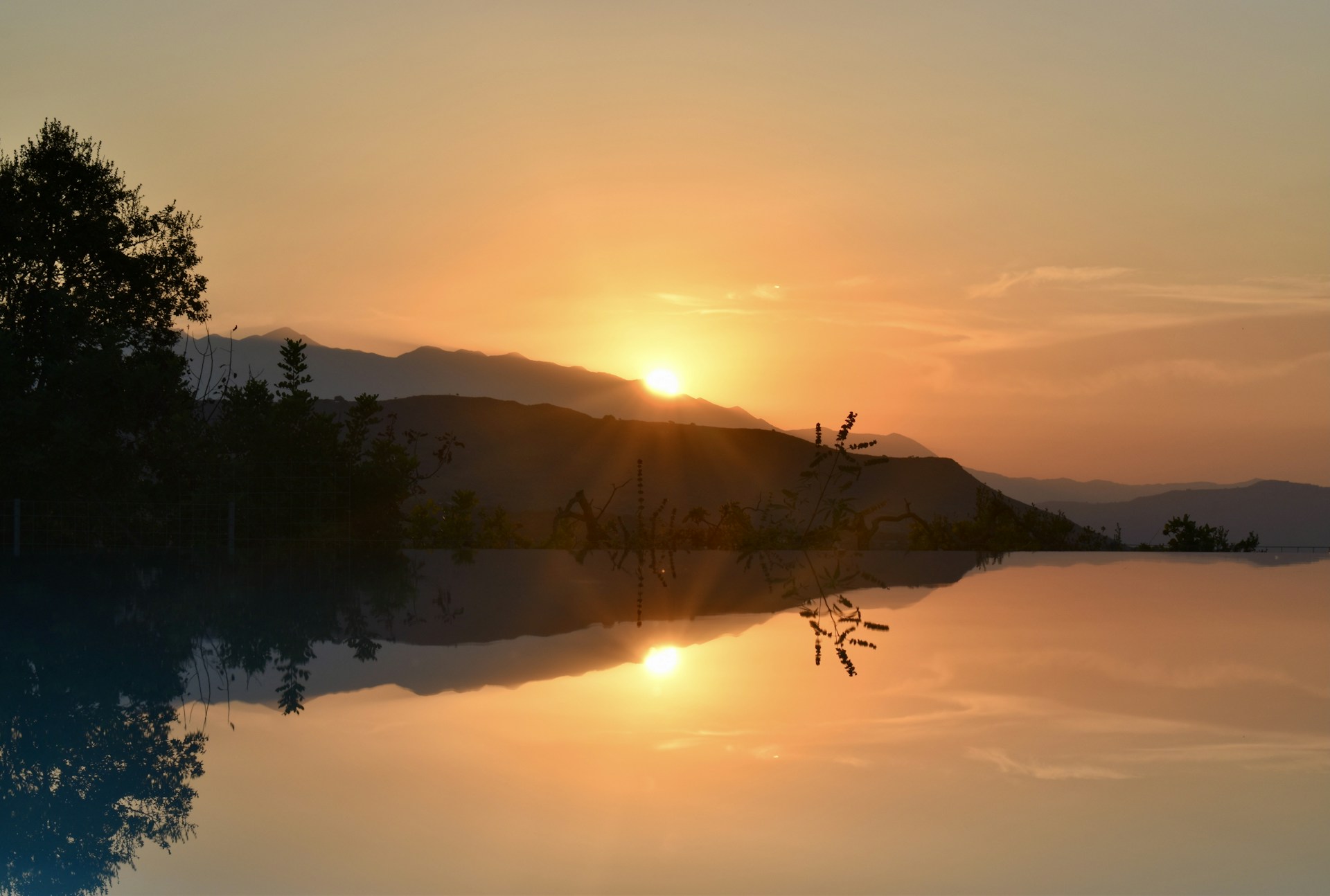 a body of water with trees and mountains in the background