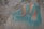 A textured concrete surface with weathered blue and orange paint, showing signs of aging and chipping. The colors are irregularly distributed over the rough, uneven surface.