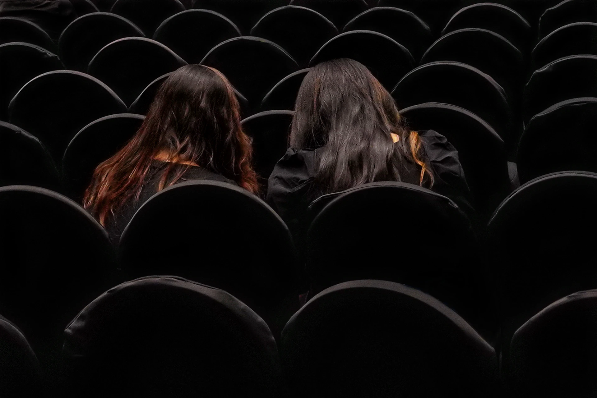 a group of people sitting in a dark room
