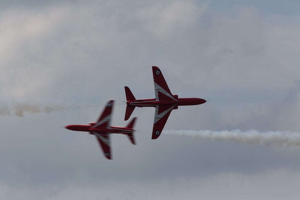 two red airplanes flying in the sky