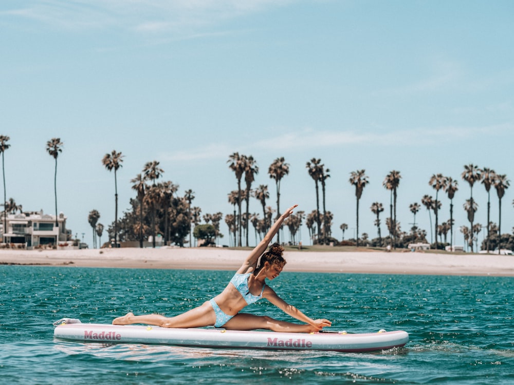 a person doing a yoga pose on a surfboard in the water