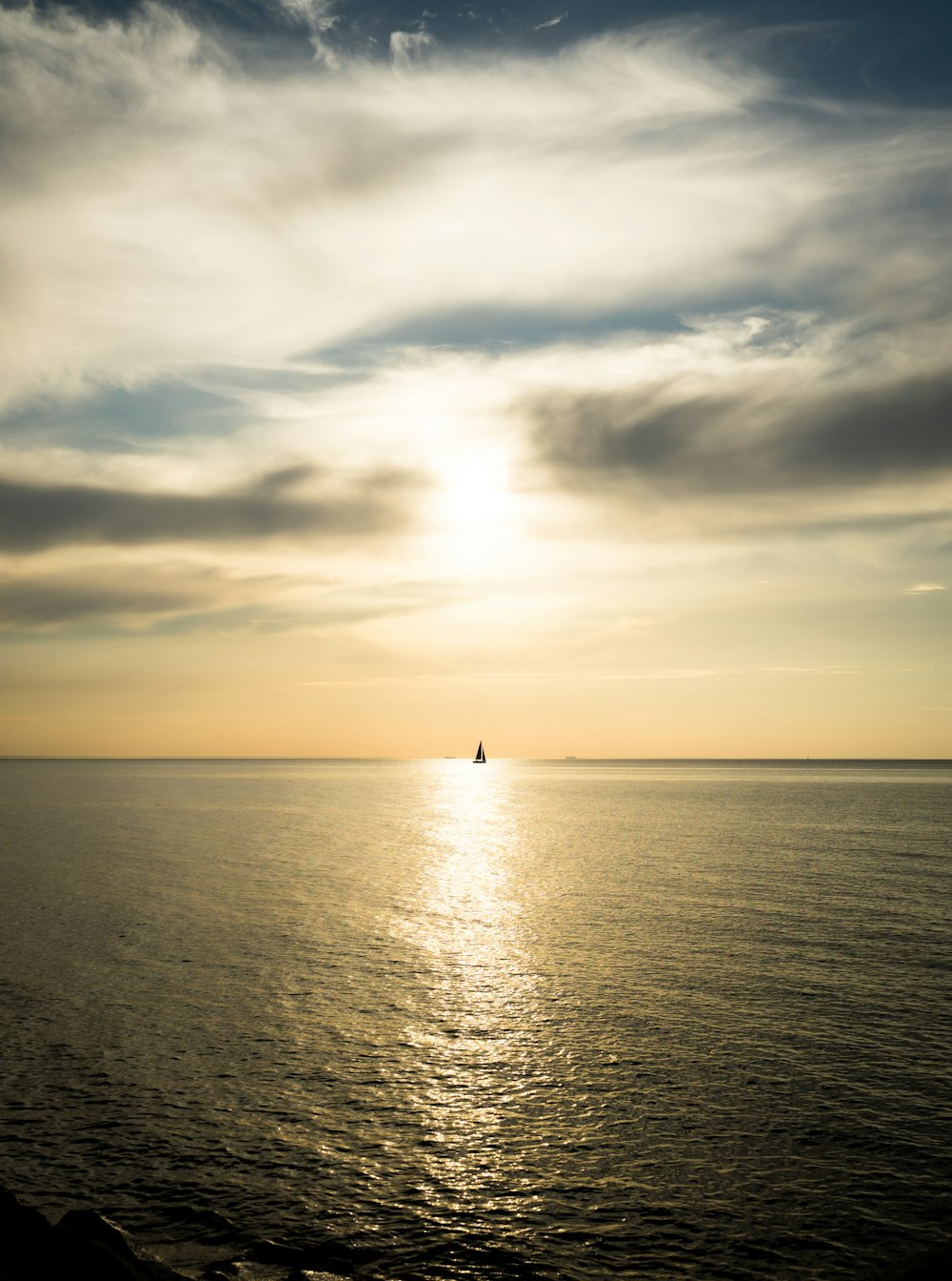 a body of water with a boat in it and a cloudy sky above