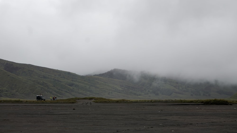 a road with a car on it and hills in the back