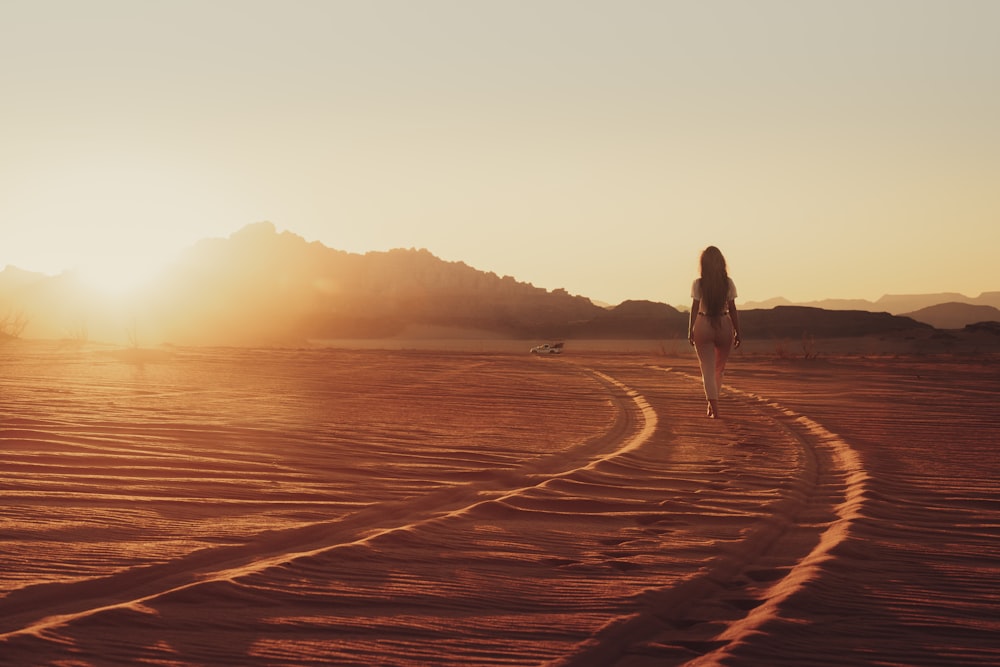 a person walking on a sandy beach