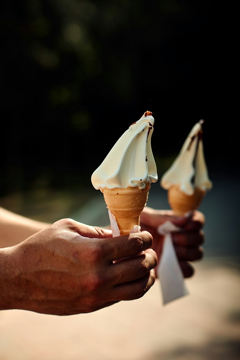 a few hands holding ice cream cones