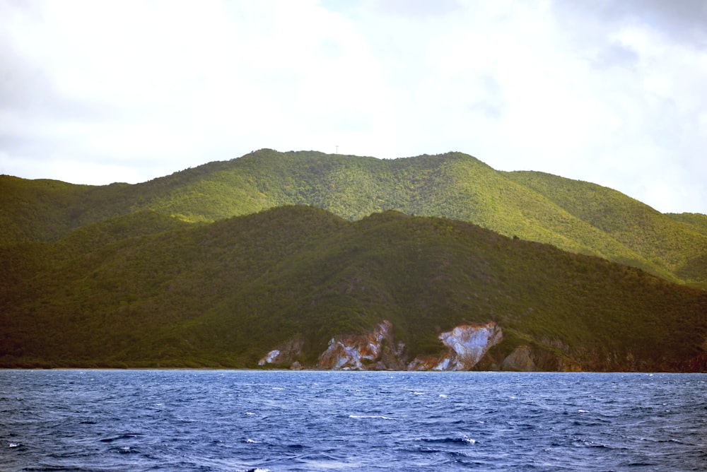 a body of water with a hill in the background