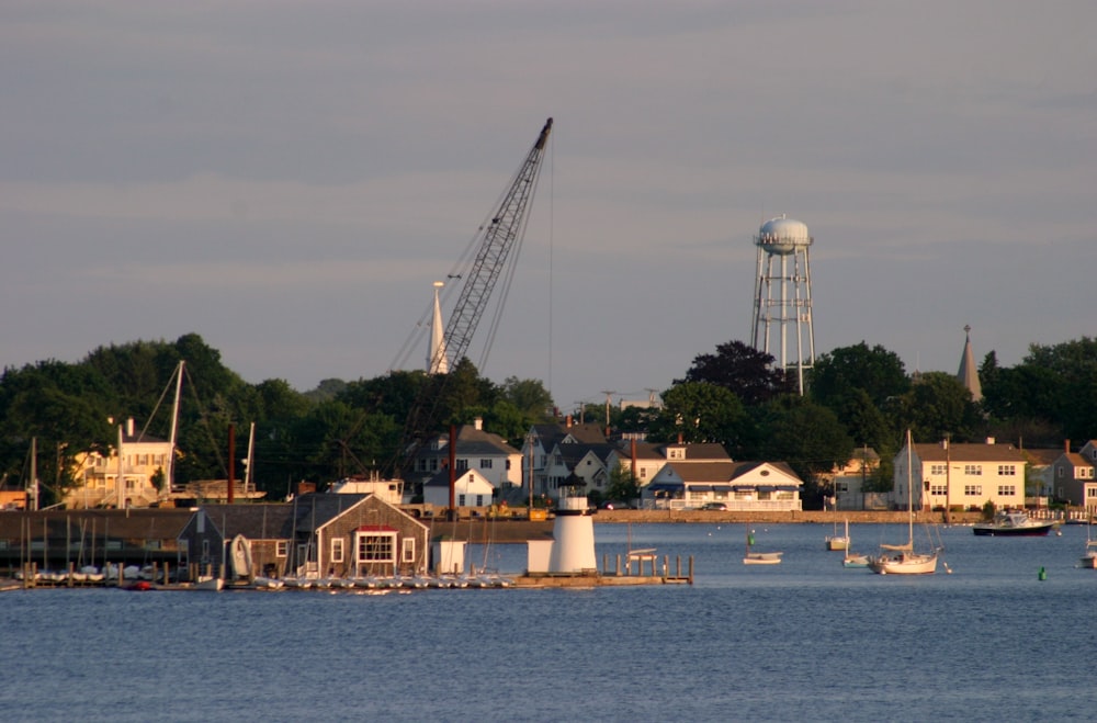 a body of water with buildings and cranes in the background
