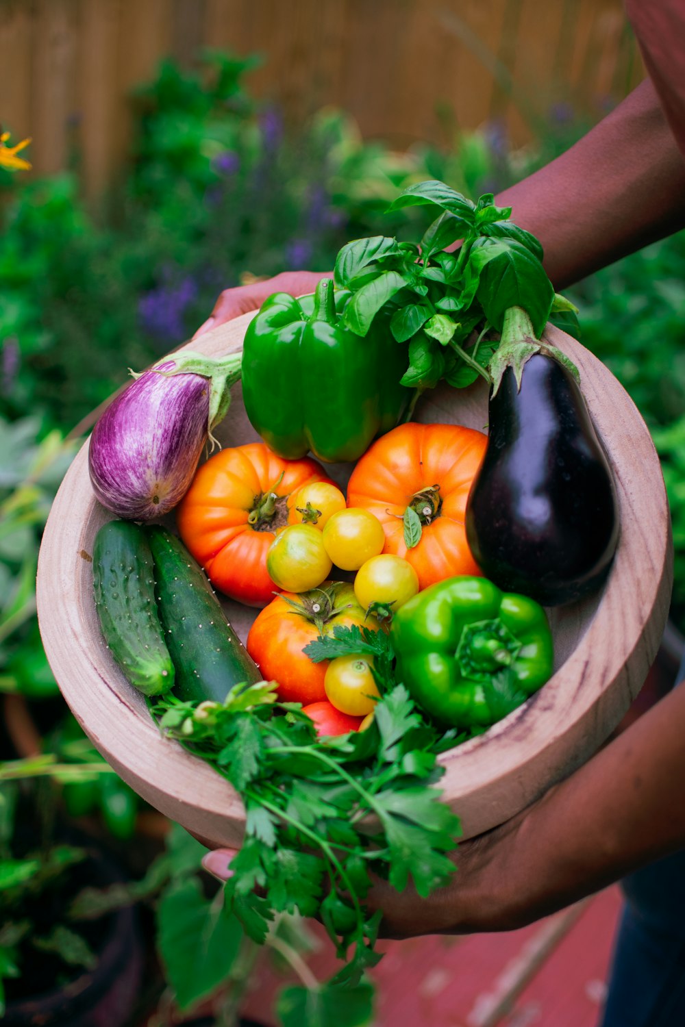 a hand holding a bunch of colorful peppers