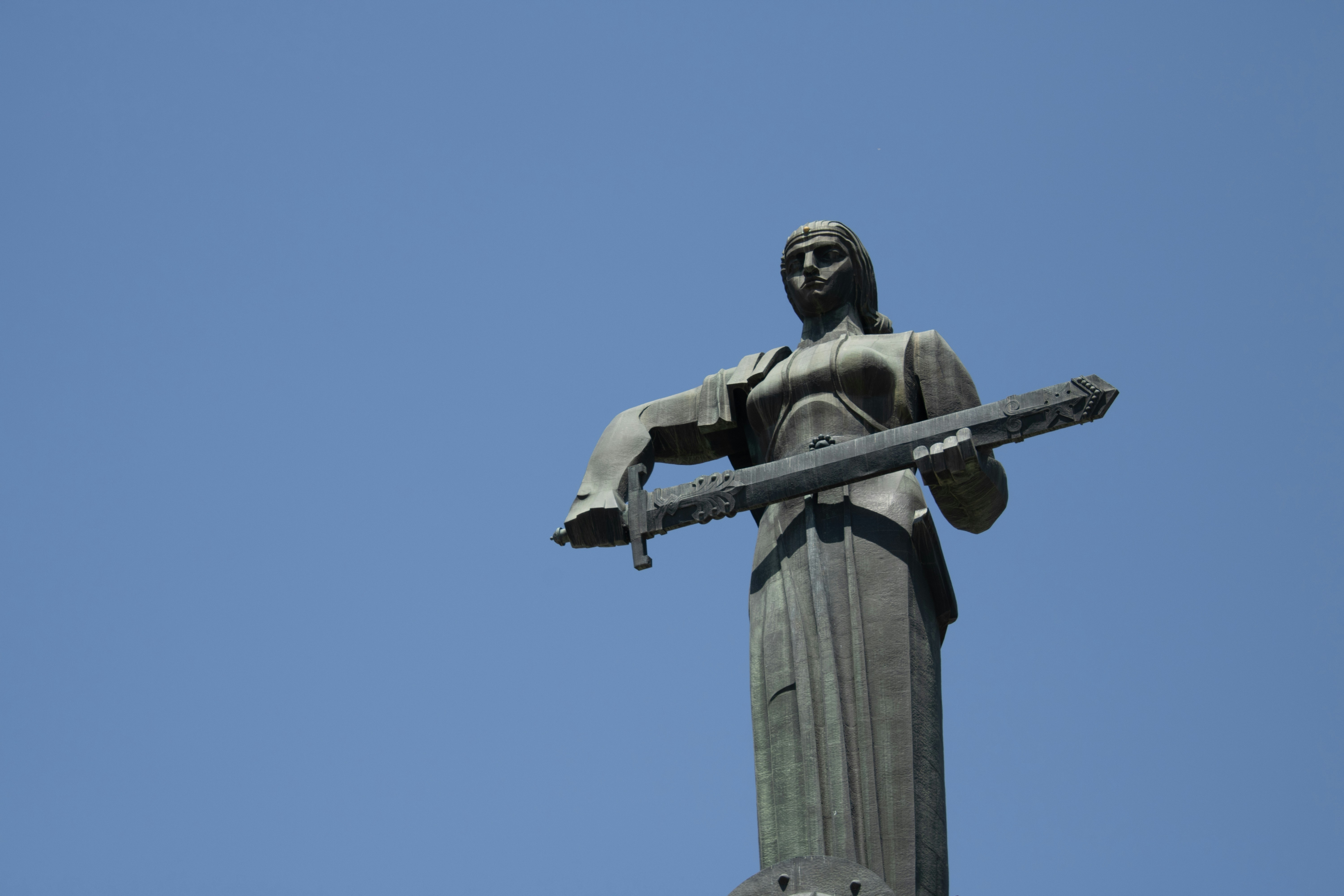 una statua di una persona che tiene una croce