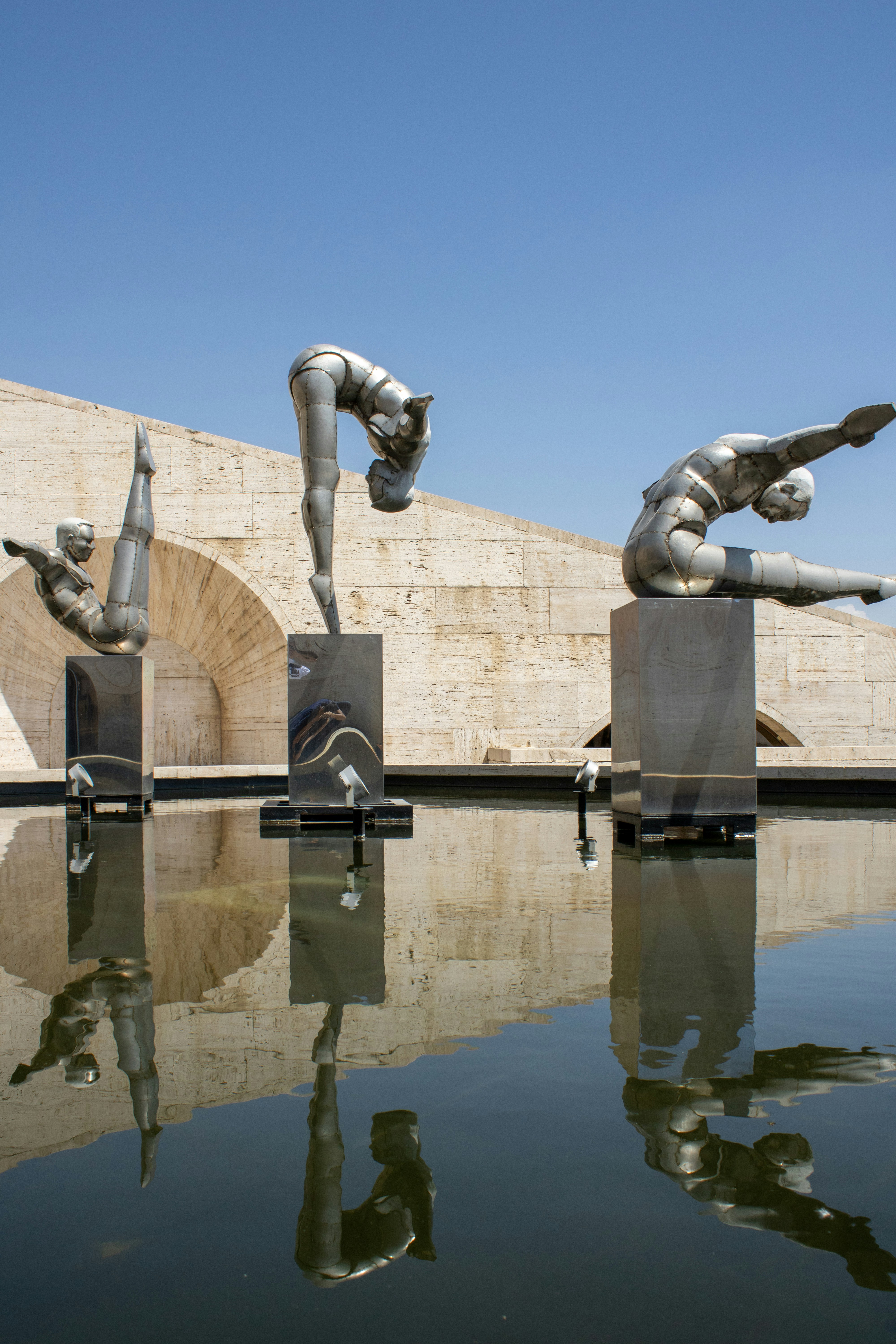 una statua di una persona che tiene una pistola di fronte a un edificio