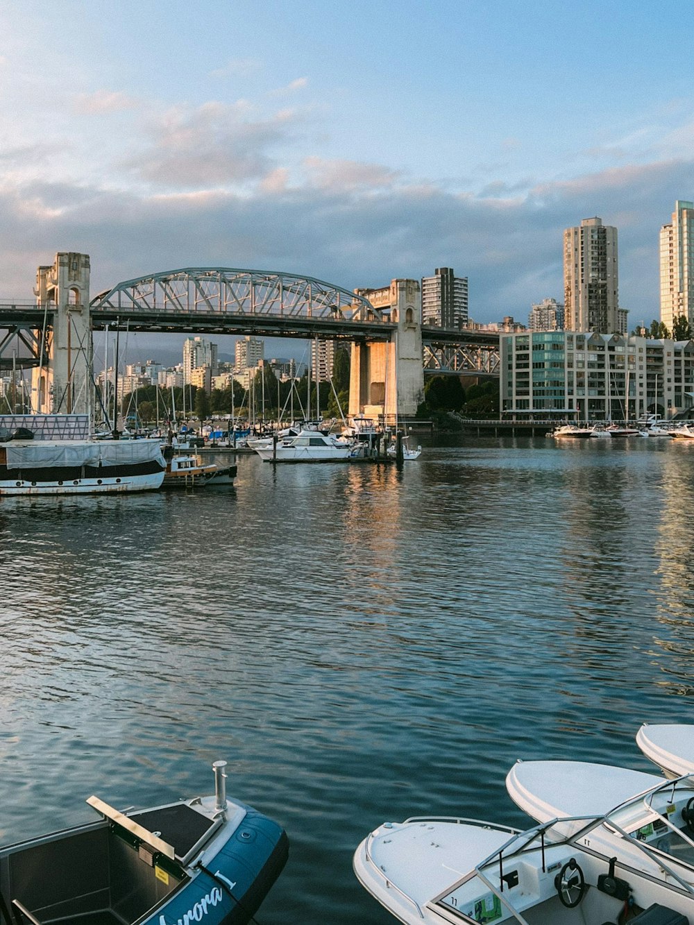 a body of water with boats and a bridge in the background