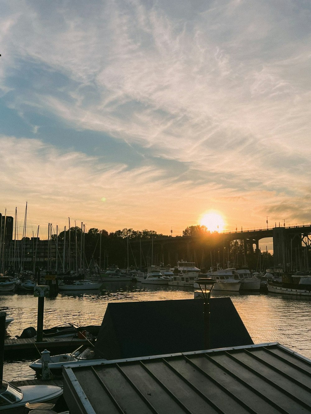 a dock with boats and a sunset