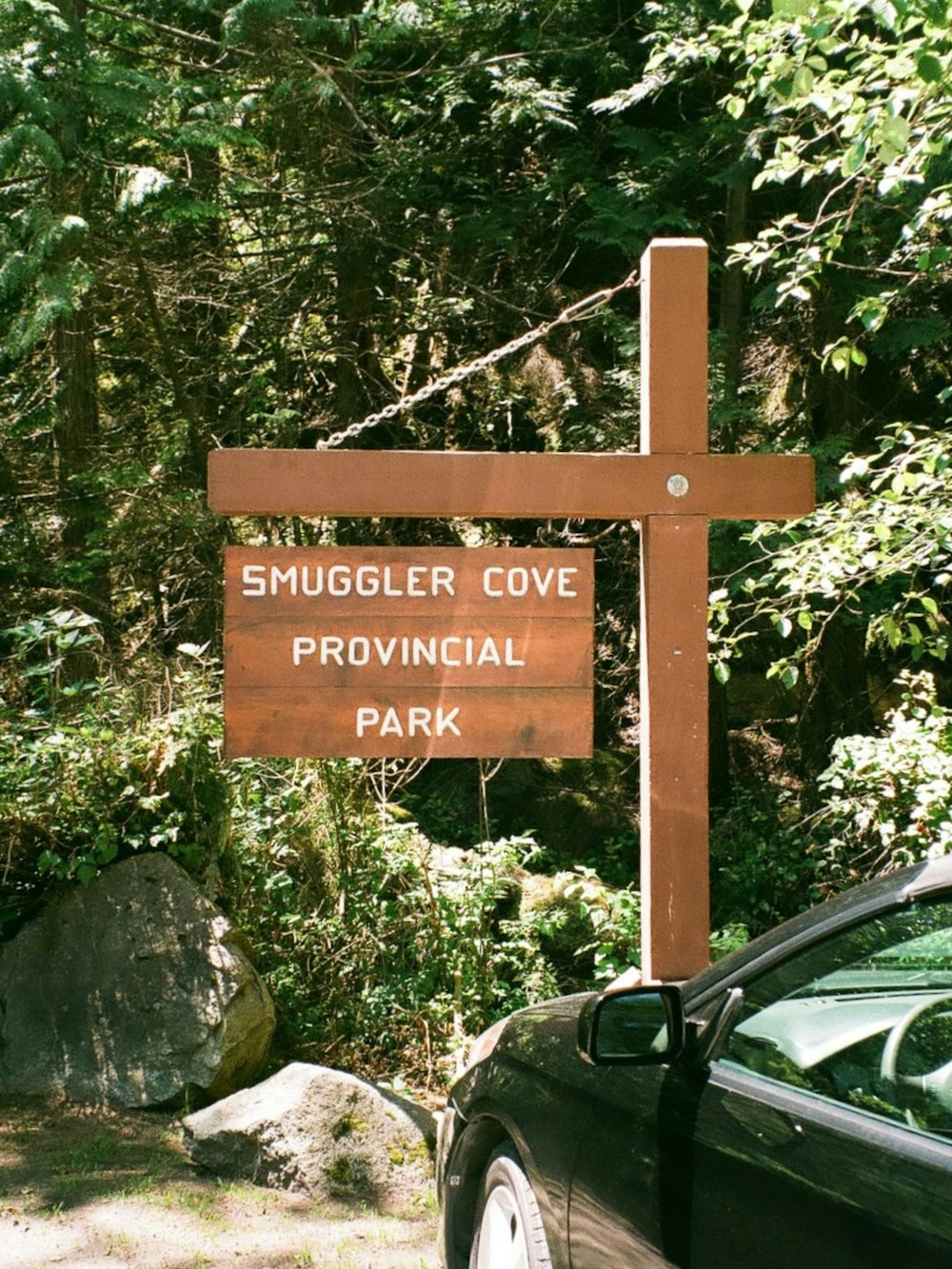 a sign with a car in the background