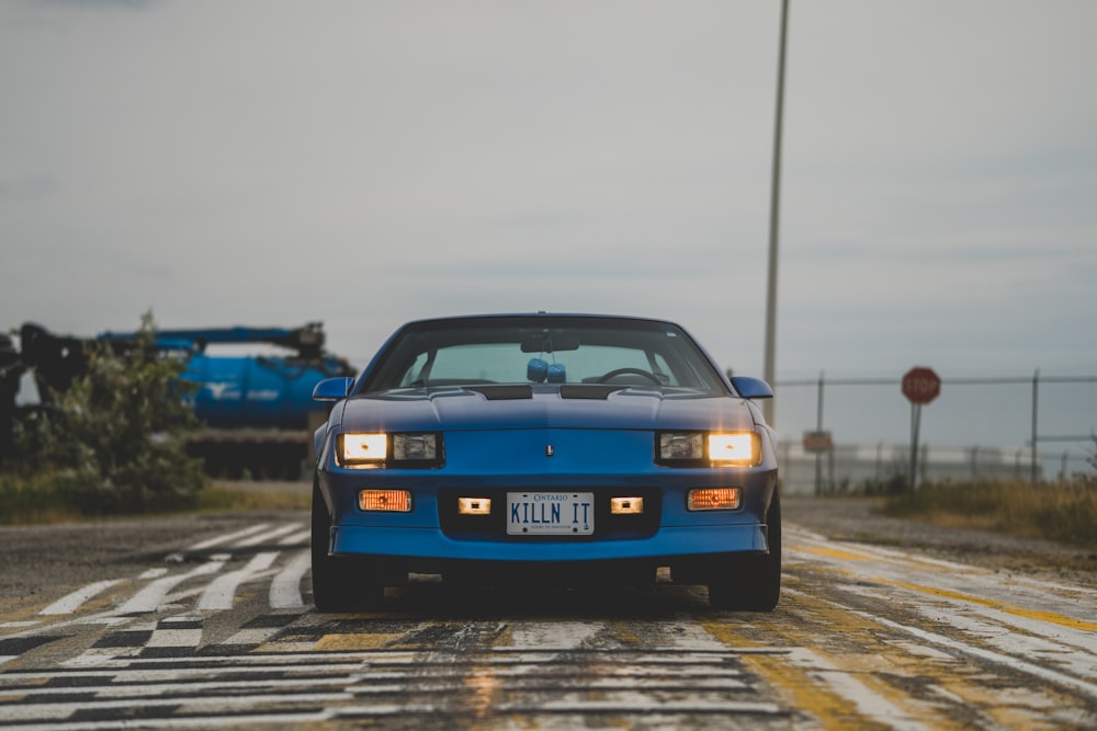 a blue car on a wet road