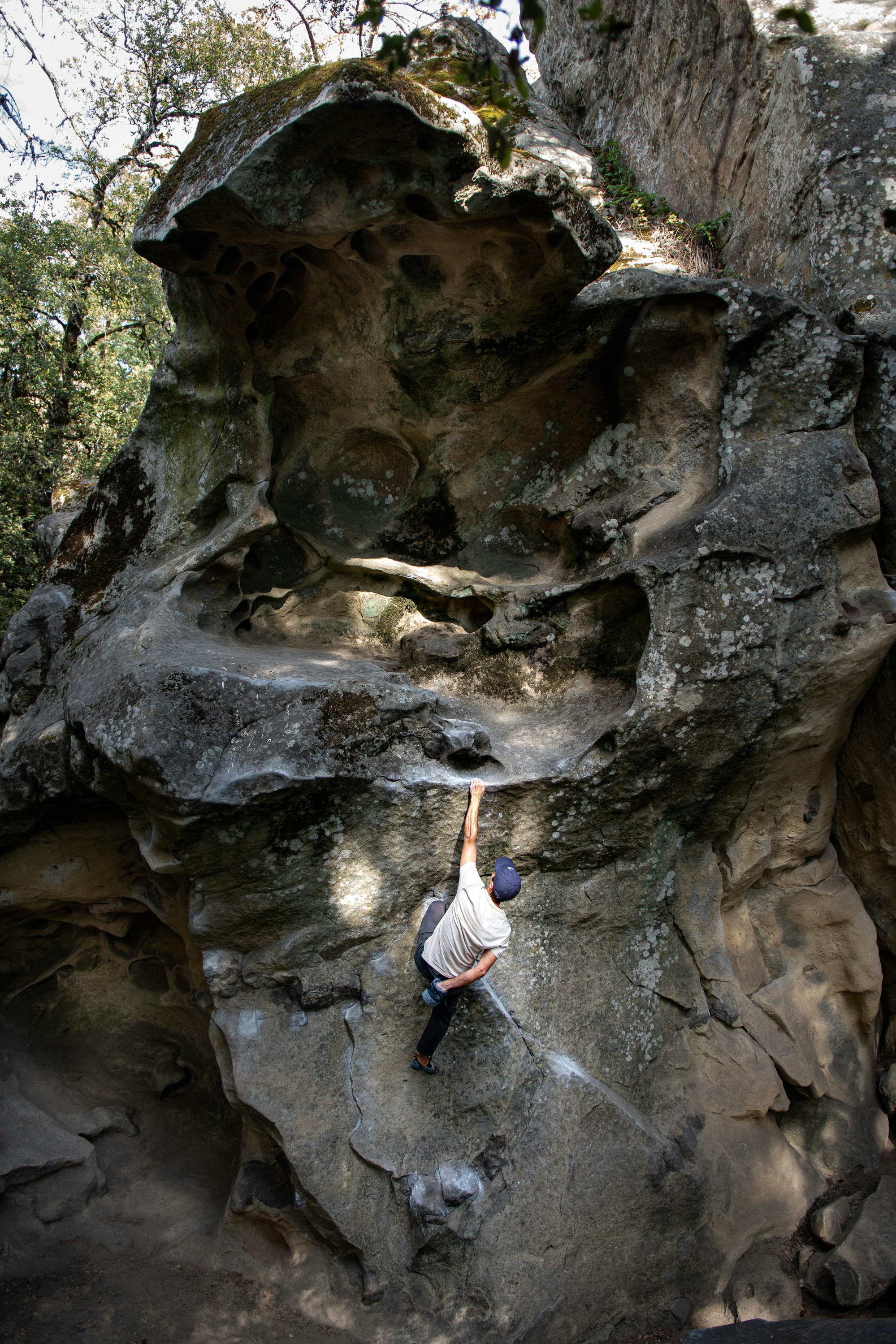 A boulderer with one leg swung out to the side as a counterweight on a steep wall