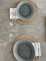 Woven jute table mats arranged neatly under ceramic dishes at a farmhouse dining table.
