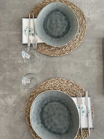 Close-up of biodegradable bagasse plates and bowls neatly arranged on a rustic wooden table.