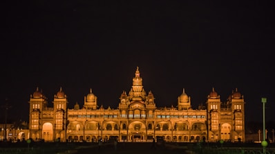 a large building with many arches with Mysore Palace in the background