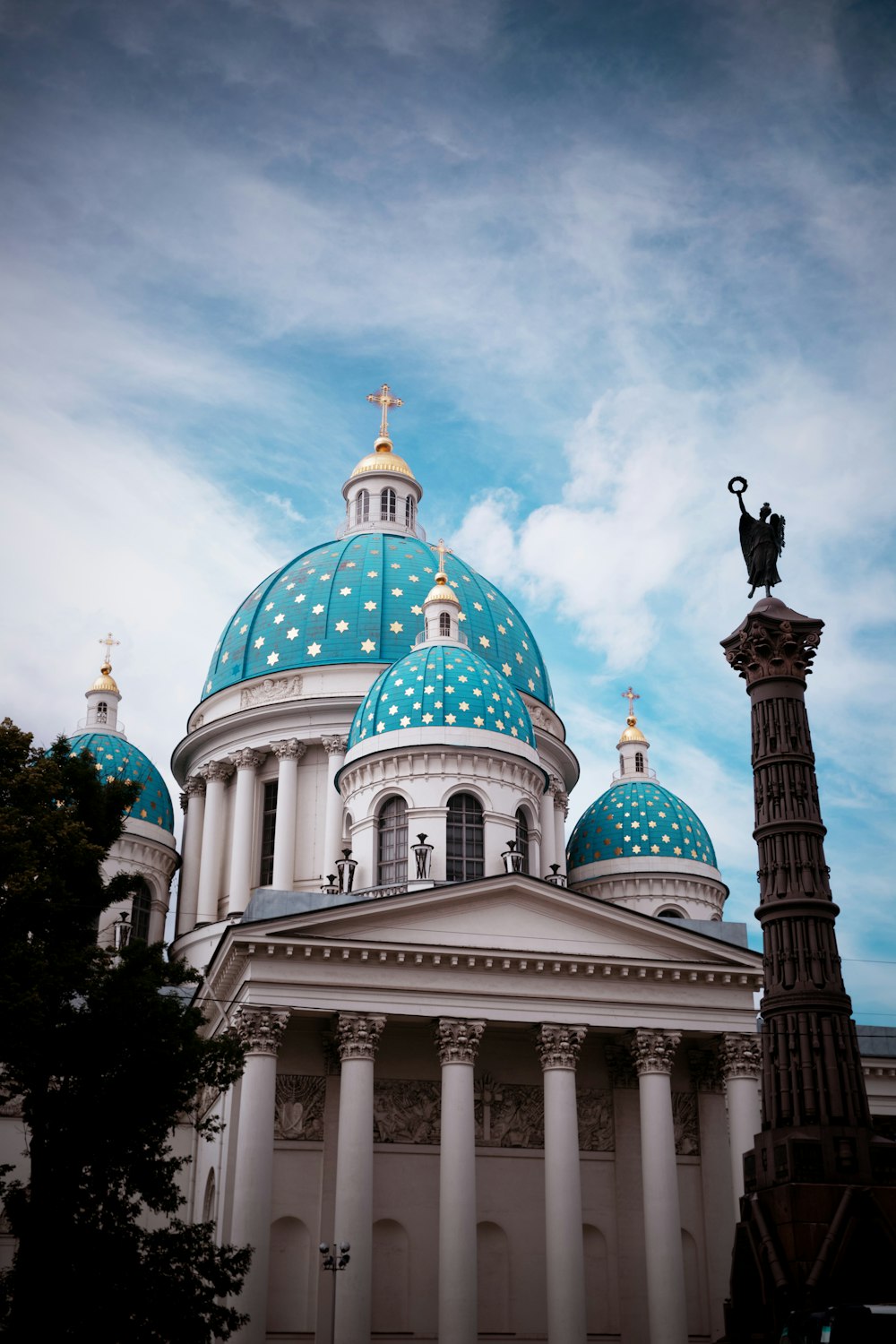 a white building with a blue dome and a statue on top