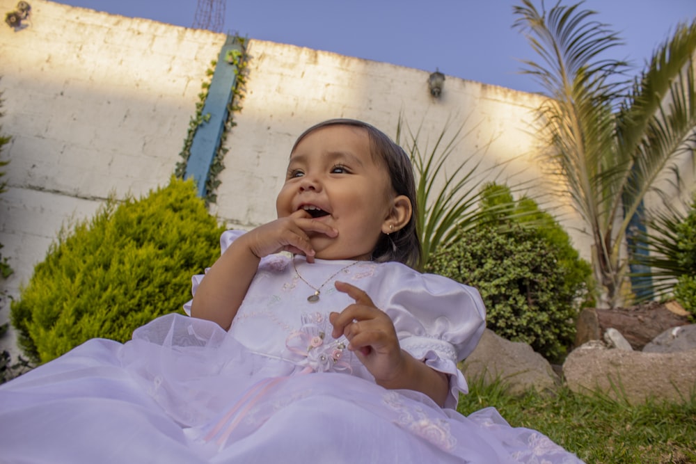 a baby in a white dress