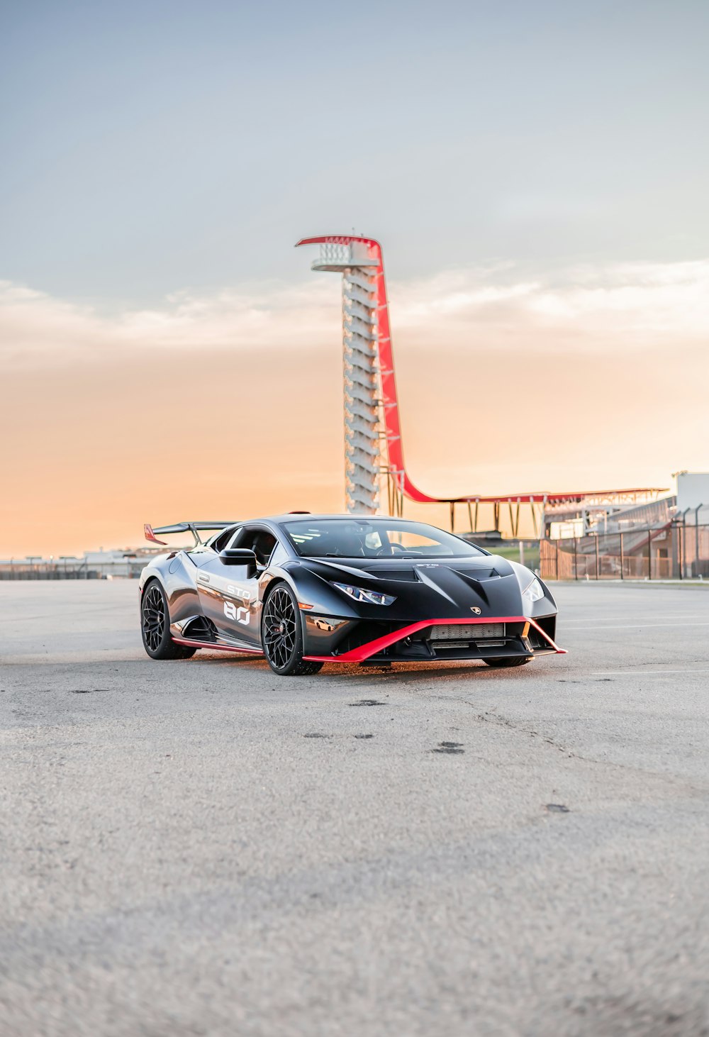 a sports car parked in front of a red tower