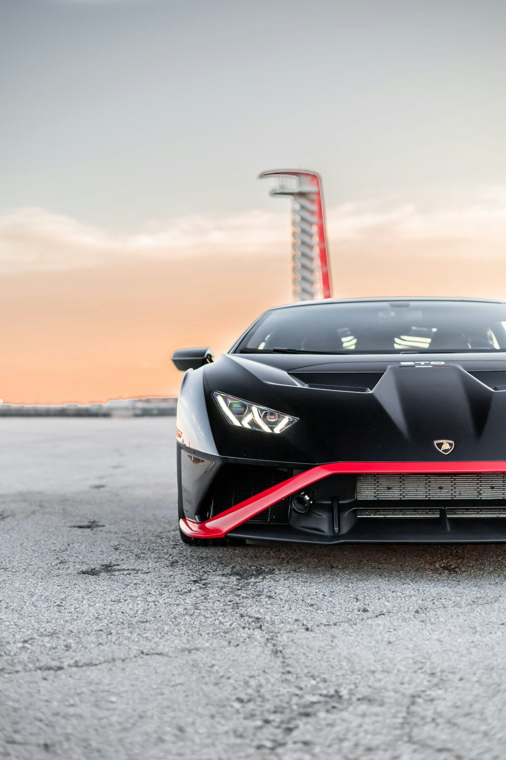 a black car with a red tower in the background