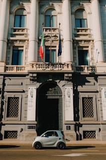 a car parked in front of a building with columns and a flag