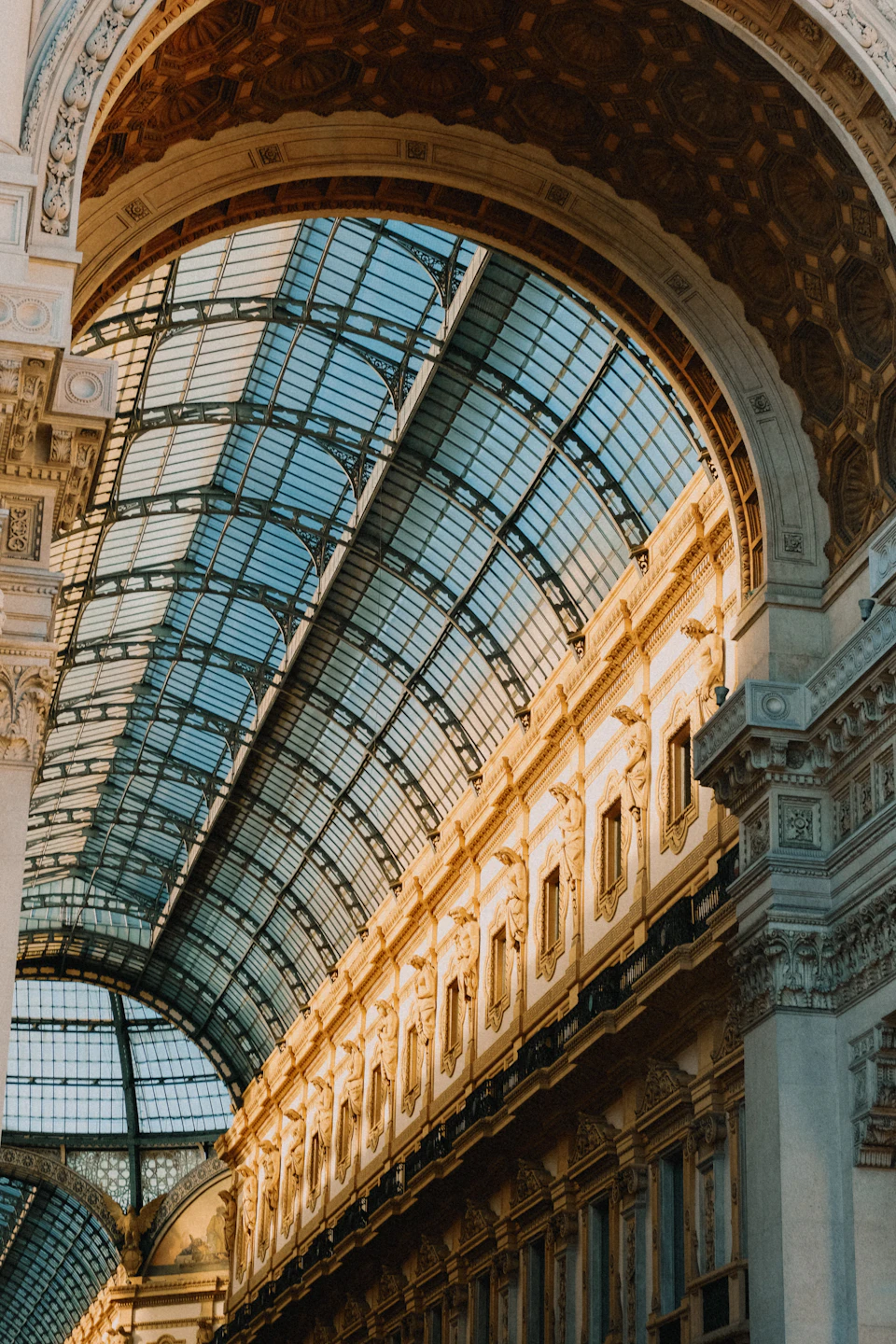 Grand, ornate building with glass ceiling, showcasing intricate architectural details and majestic design