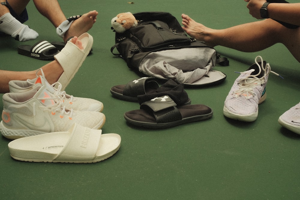 un groupe de personnes assises par terre avec leurs chaussures