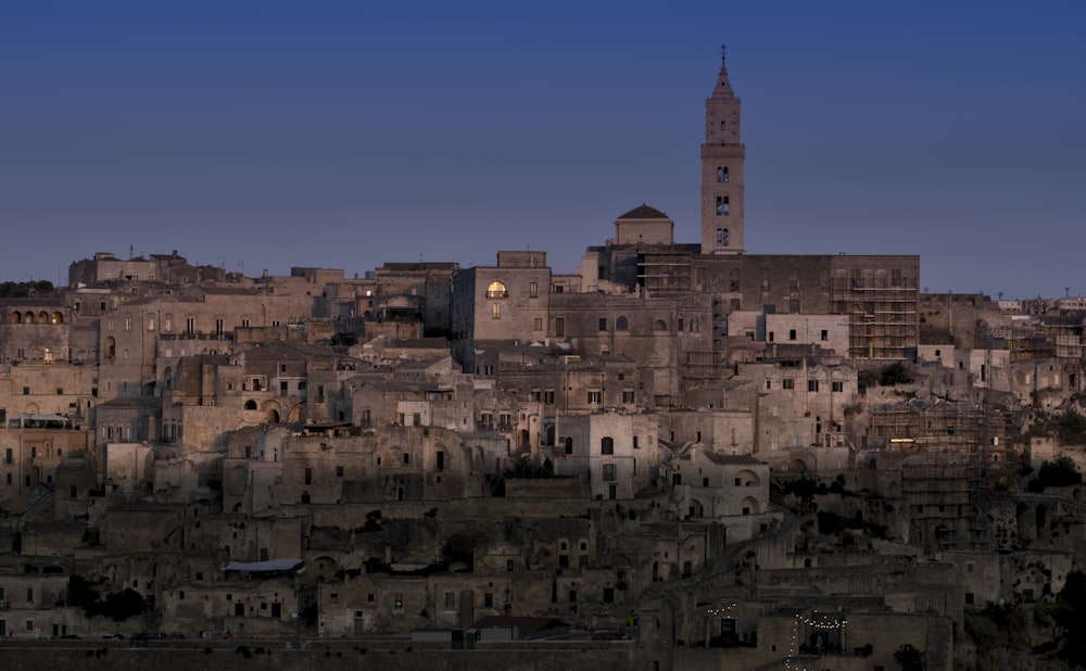 a large city with a tall tower with Matera in the background