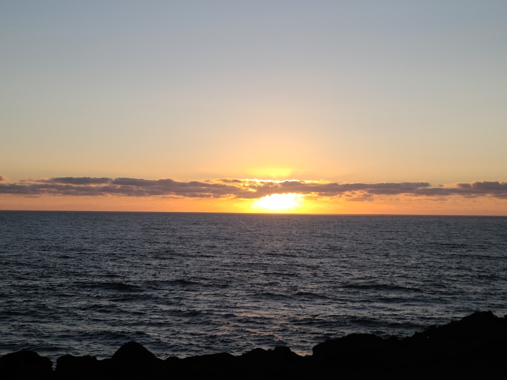 a sunset over the ocean with Sunset Beach in the background