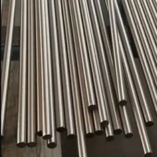 Multiple metallic tubes arranged in parallel lines, reflecting light and exhibiting a shiny surface. They are uniformly cylindrical and appear to be made of stainless steel.
