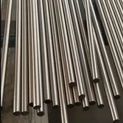 Multiple metallic tubes arranged in parallel lines, reflecting light and exhibiting a shiny surface. They are uniformly cylindrical and appear to be made of stainless steel.