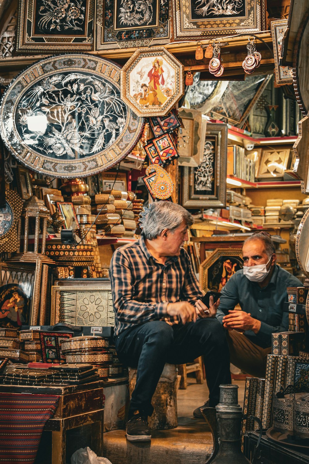 a man and a woman sitting in a room with art on the walls