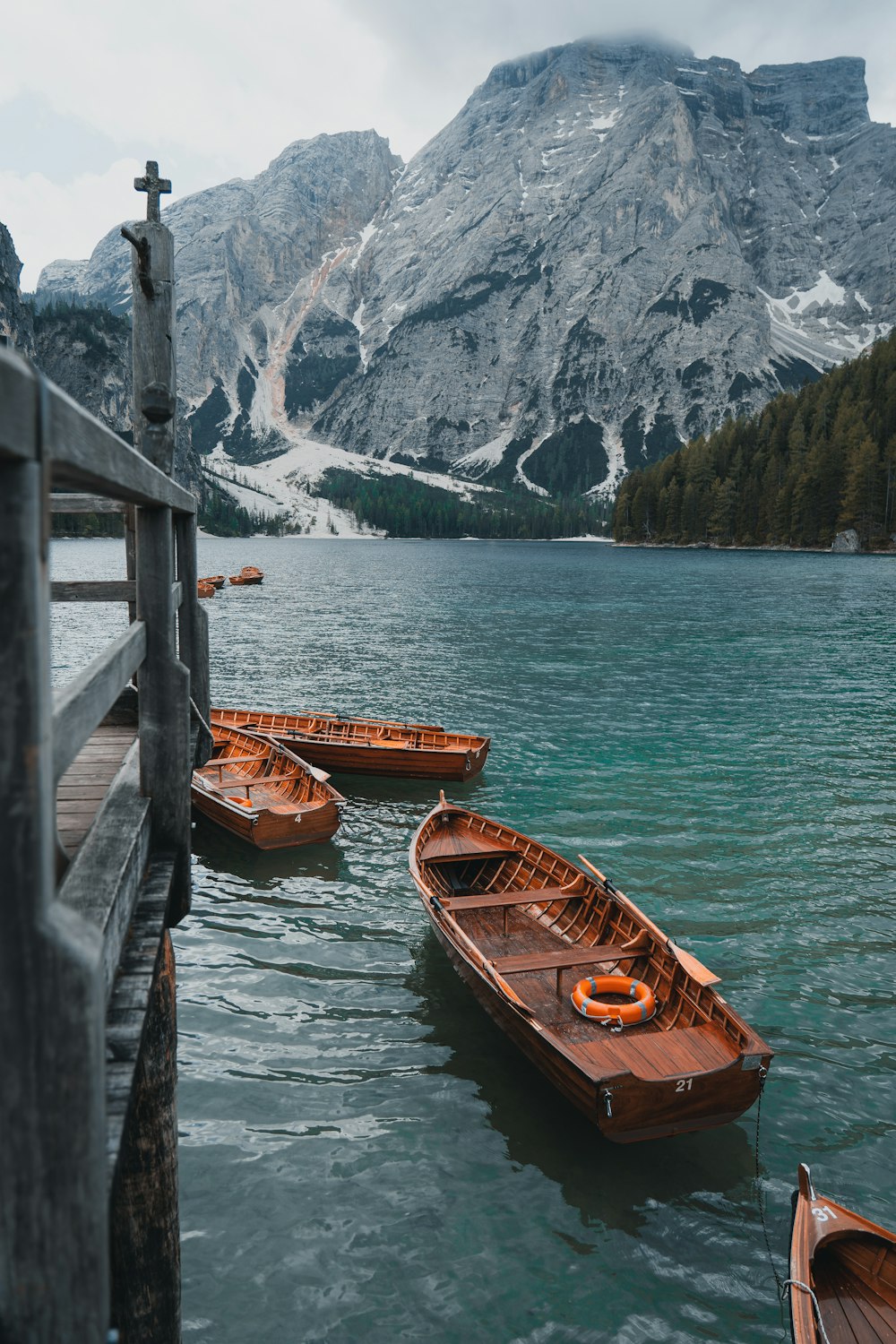 a group of boats in a body of water with mountains in the background