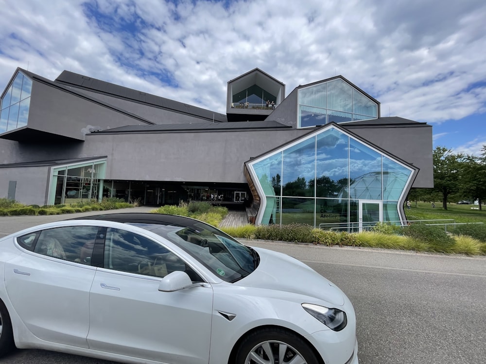 a white car parked outside a building