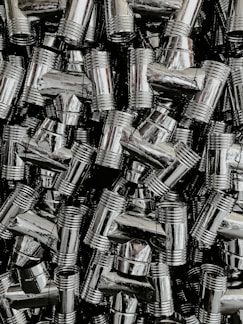 A close-up of shiny new plumbing pipes and fittings neatly arranged on a wooden surface.