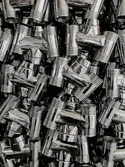 Close-up of shiny stainless steel flanges stacked neatly in a workshop.