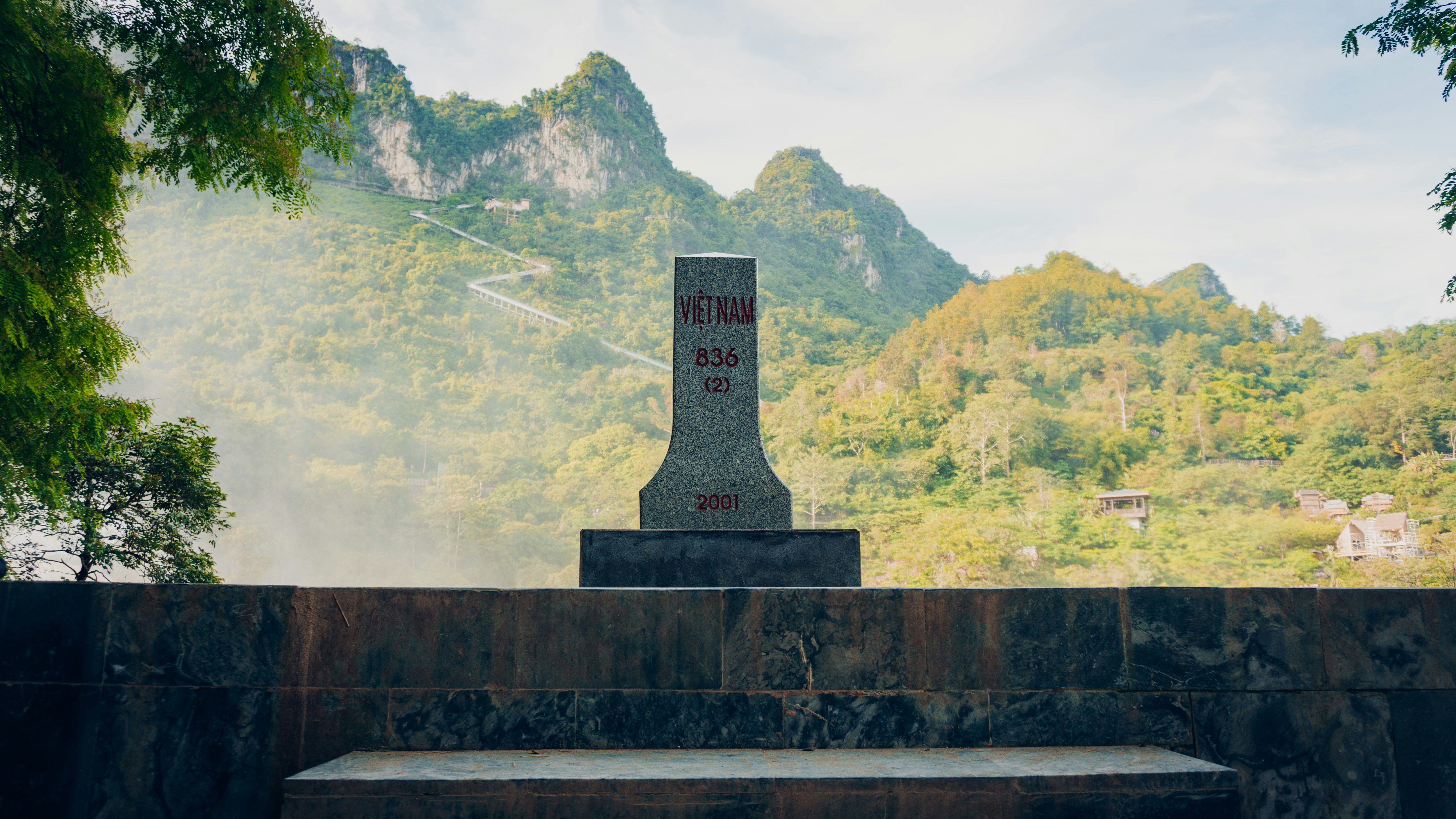a stone monument with a hill in the background
