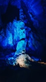 A dark, mysterious cave interior illuminated by subtle blue light sources.