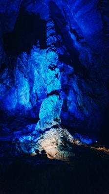 A dark, mysterious cave interior illuminated by subtle blue light sources.