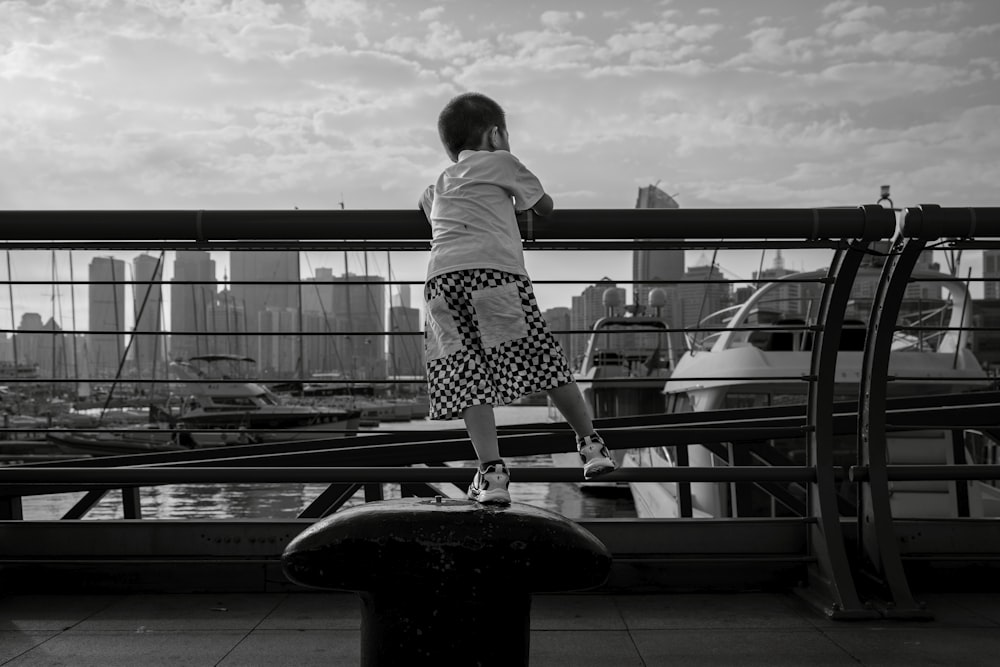 a little girl standing on a bench