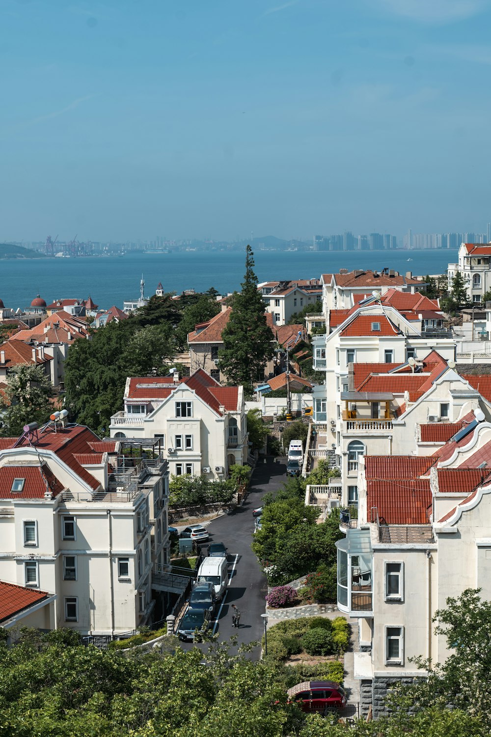 a city with red roofs and a body of water in the background