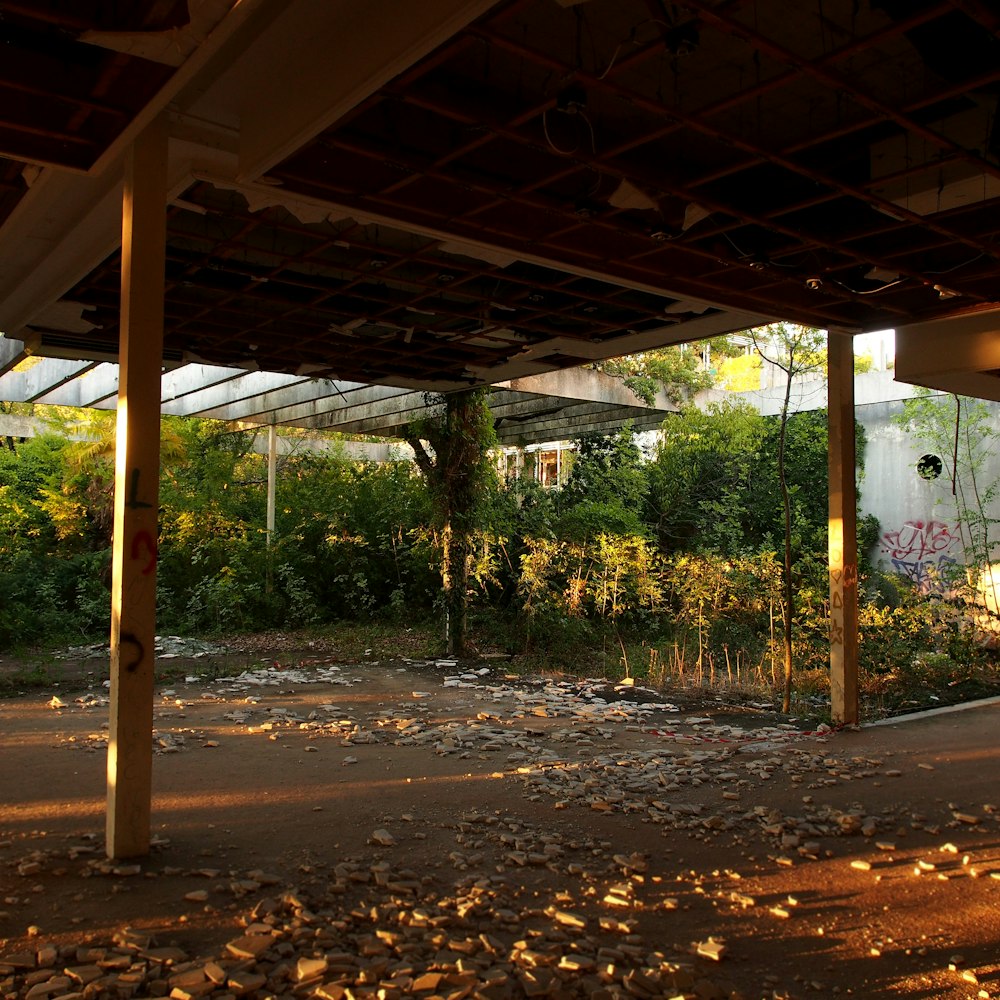 a covered area with a fence and trees in the background