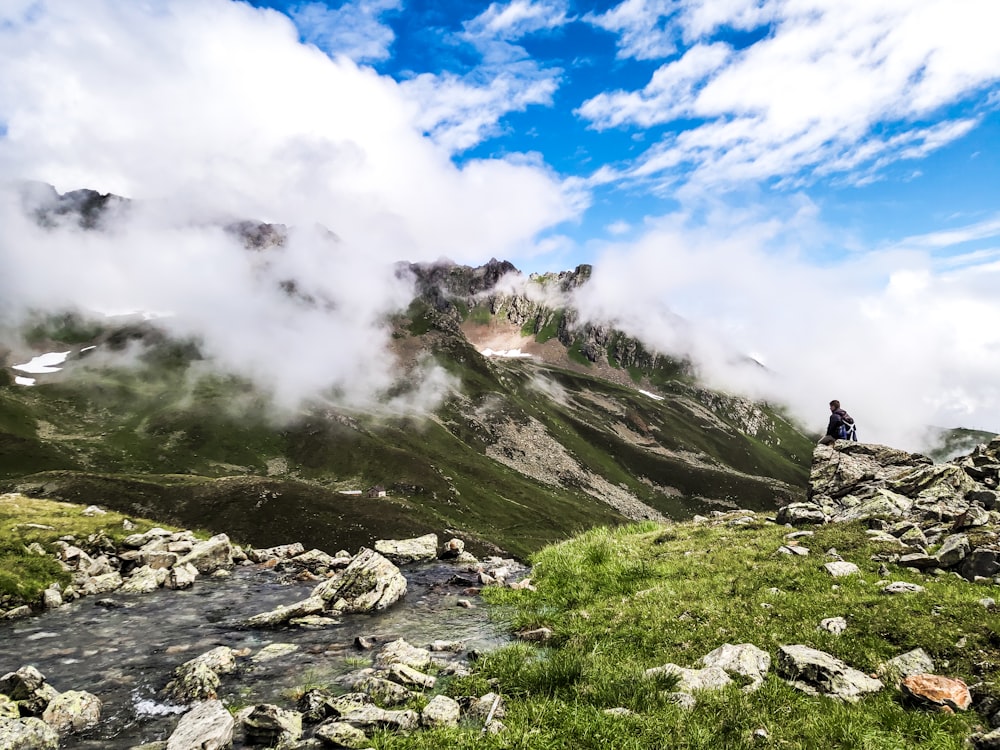 a person sitting on a rock ledge