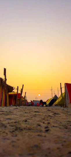 A warm sunset over the Sinai desert with Bedouin Star camp tents glowing softly in the distance.