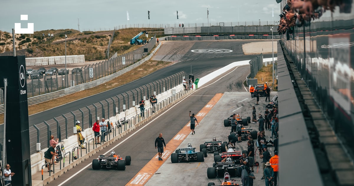 A group of people around a race car on a track photo – Free Circuit ...