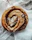 Close-up of a gooey sourdough cinnamon roll with icing dripping down the sides.