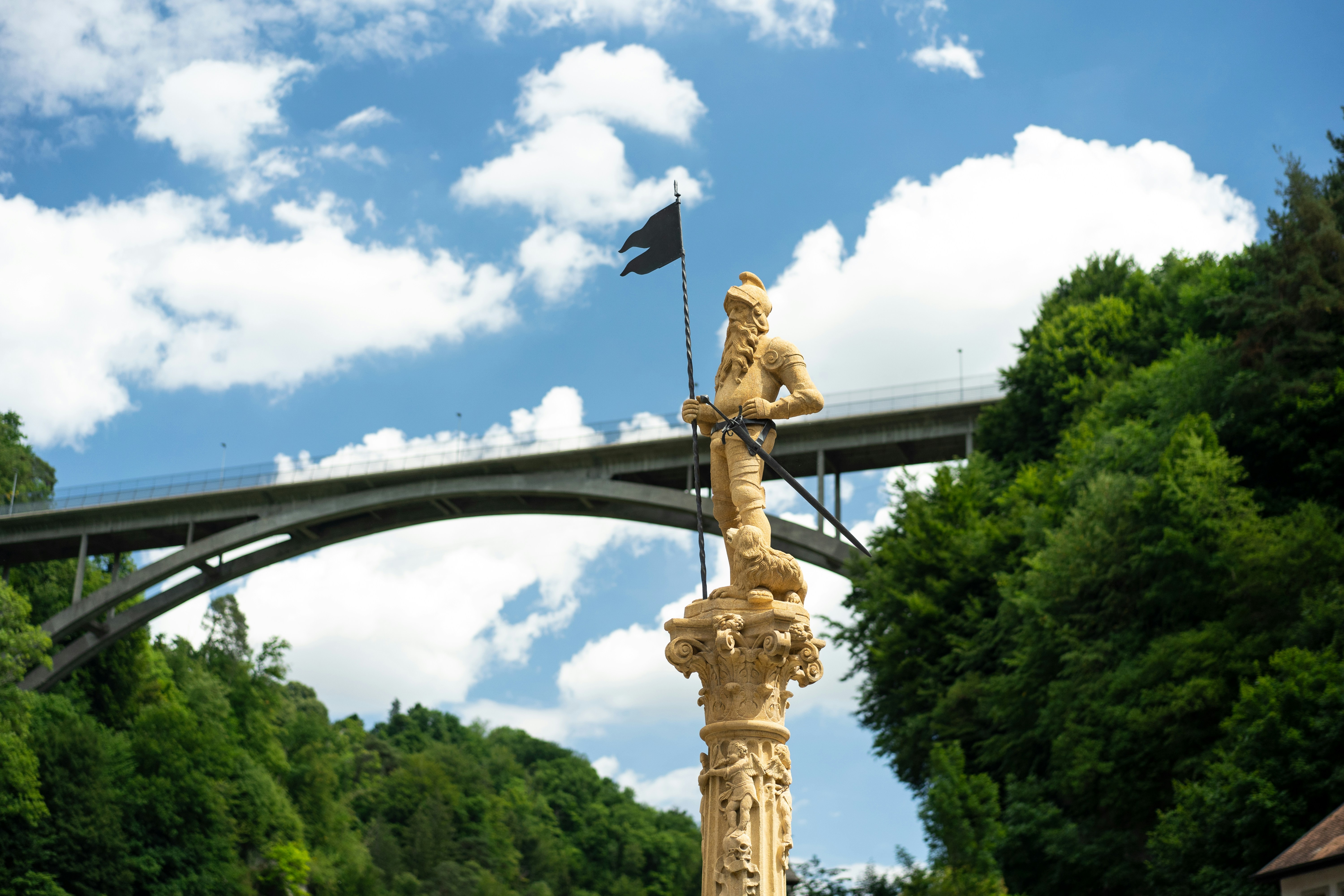 une statue d’une personne tenant un drapeau et un drapeau